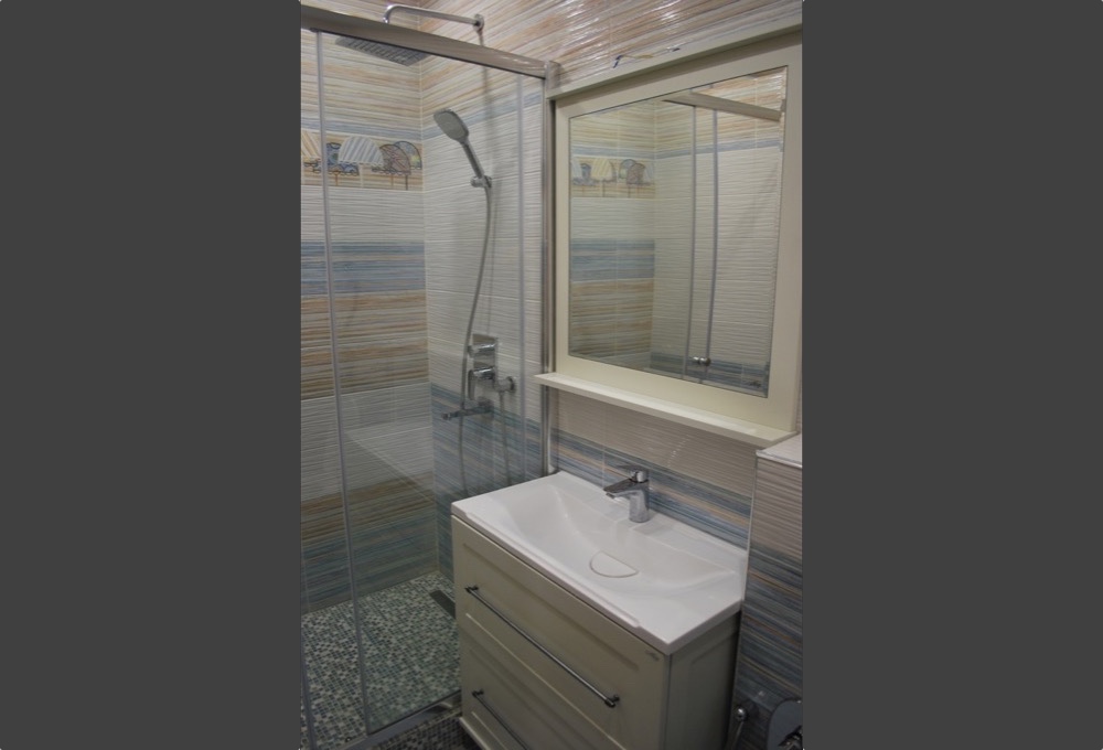 В ванной комнате использованы керамическая плитка и керамогранит.